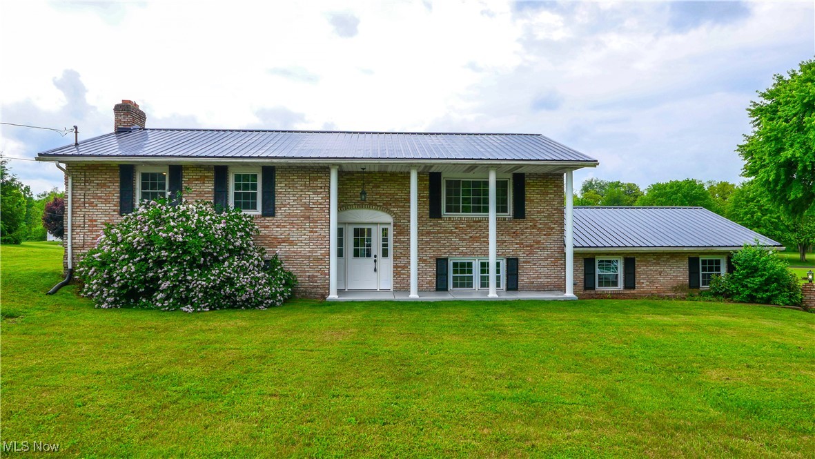 23595 Sandy Creek Road Minerva, OH 44657 - Photo 1 of 32 View of front of house with a front lawn, metal roof, and a chimney