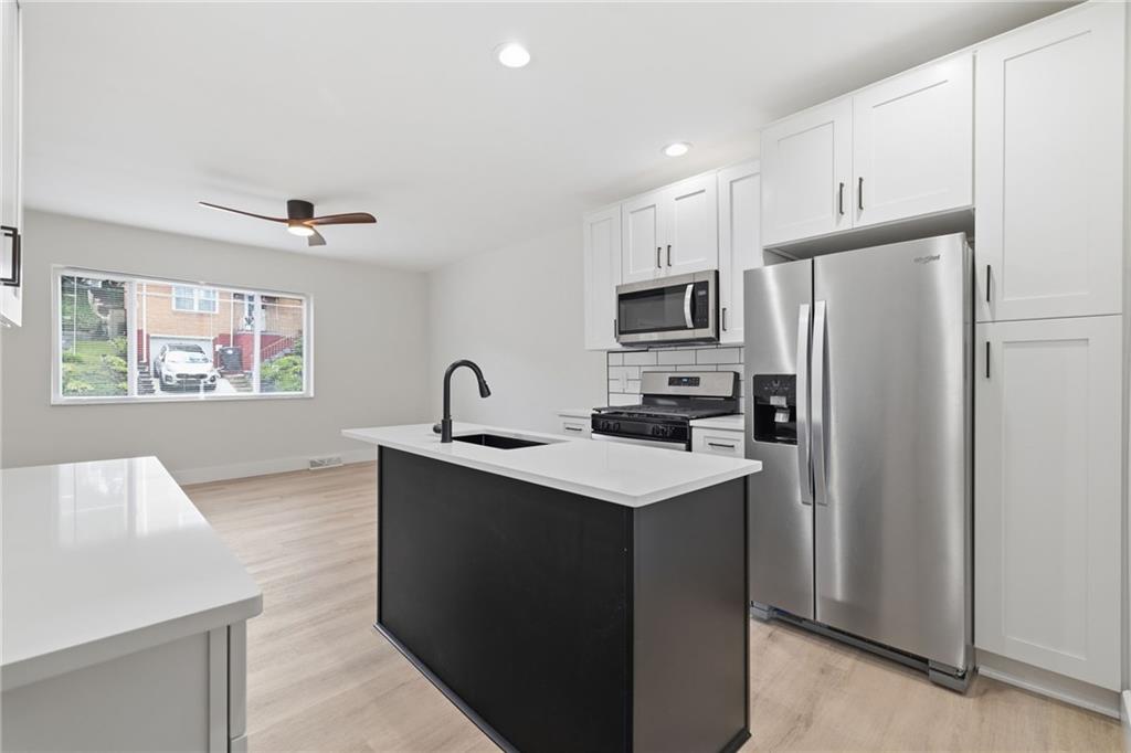 2961 Ruthwood Avenue Pittsburgh, PA 15227 - Photo 11 of 29 a kitchen with stainless steel appliances a refrigerator stove microwave and sink