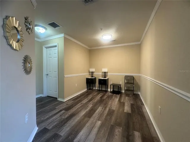 a view of a bedroom with wooden floor