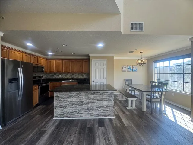 a kitchen with stainless steel appliances granite countertop a stove and a refrigerator