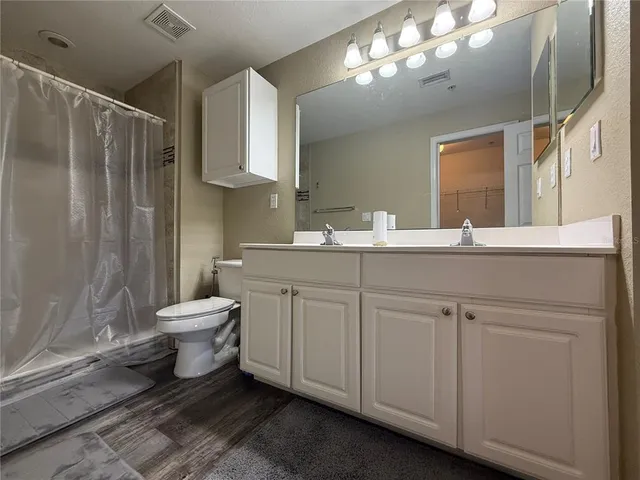 a bathroom with a double vanity sink mirror and toilet