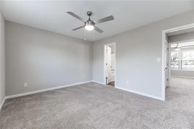 an empty room with fan and windows