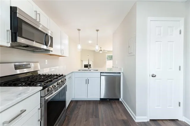 a kitchen with stainless steel appliances granite countertop a stove a sink and a microwave