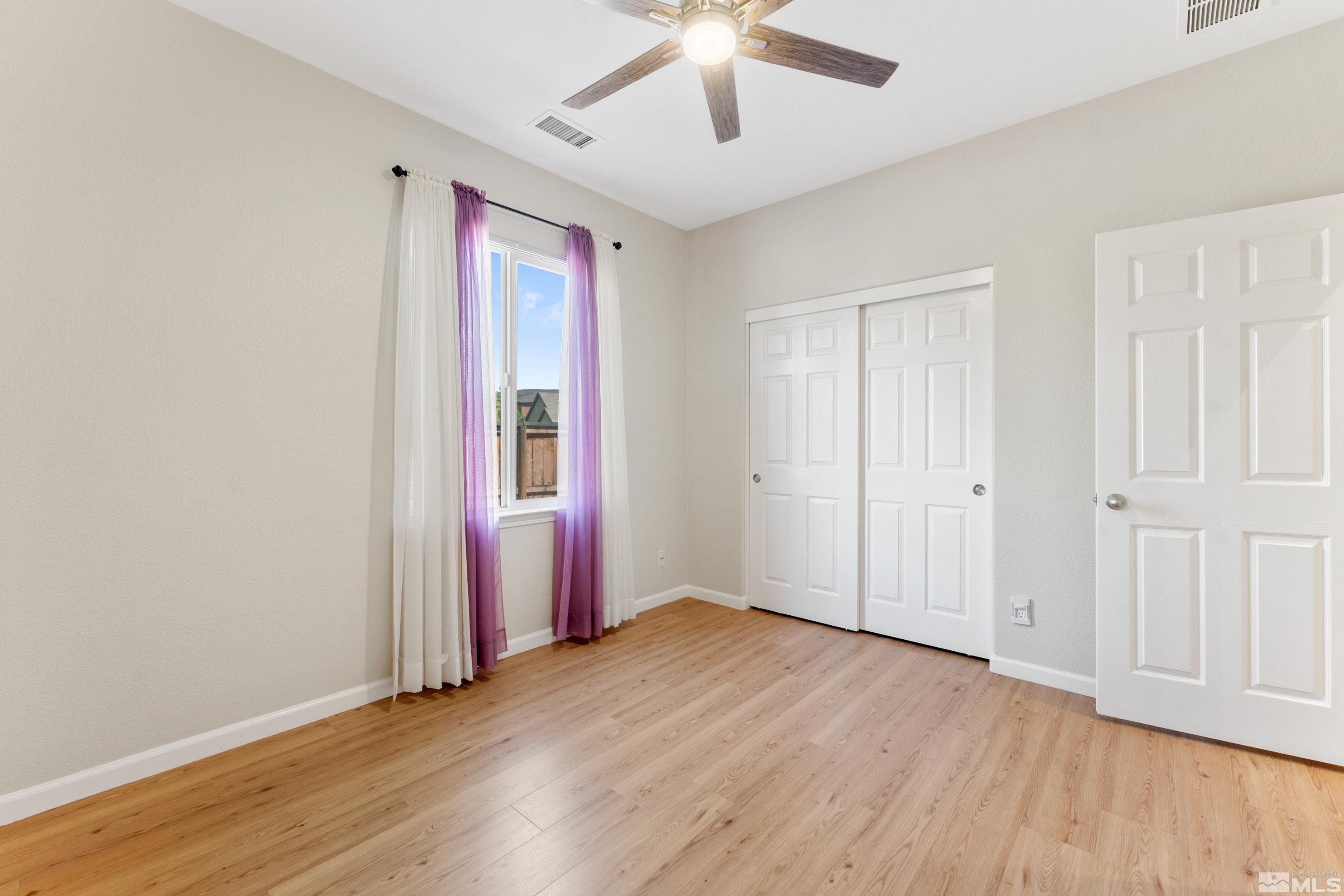 2195 Horse Prairie Road Reno, NV 89521 - Photo 15 of 39 an empty room with wooden floor chandelier fan and windows
