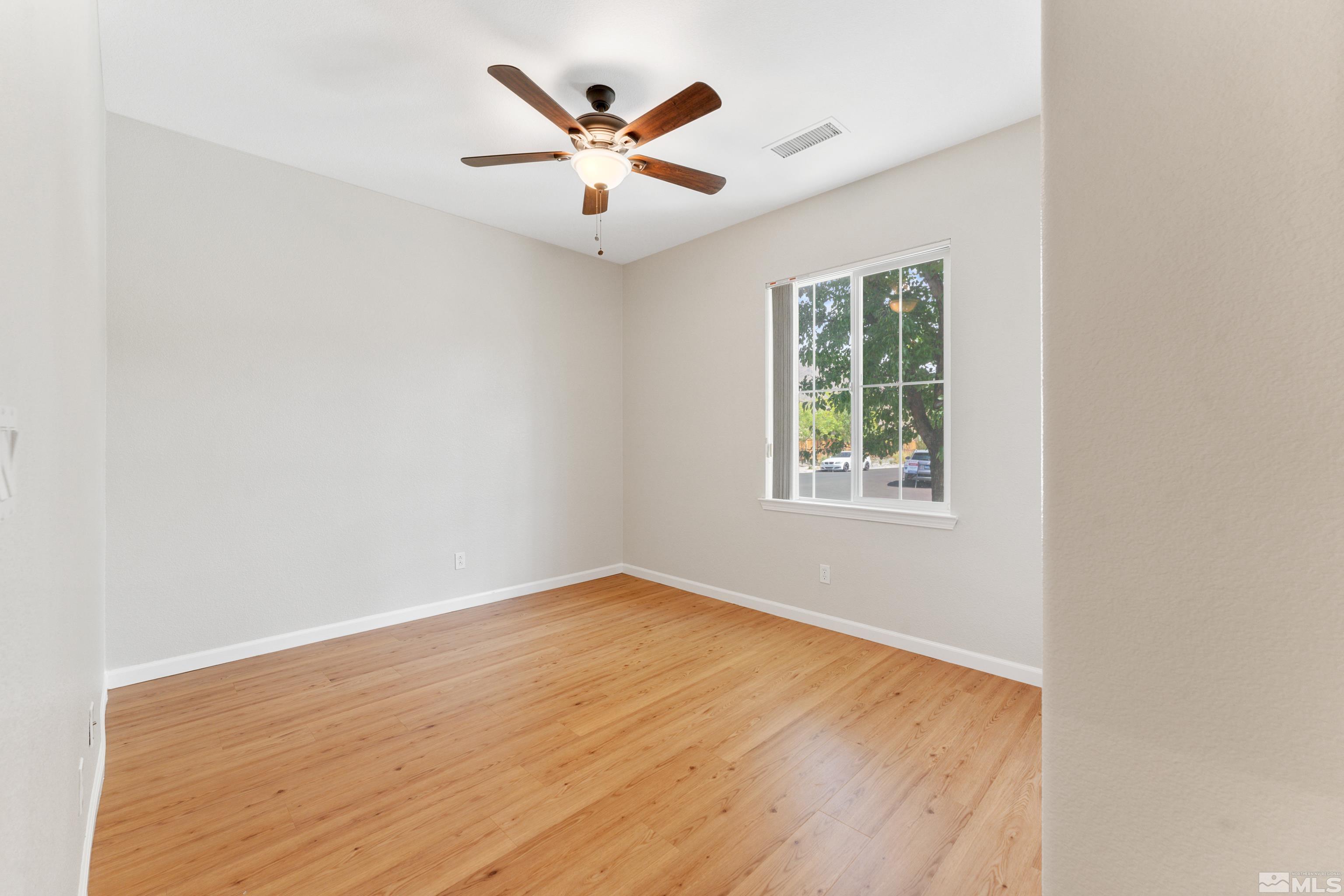 2195 Horse Prairie Road Reno, NV 89521 - Photo 16 of 39 an empty room with wooden floor and windows