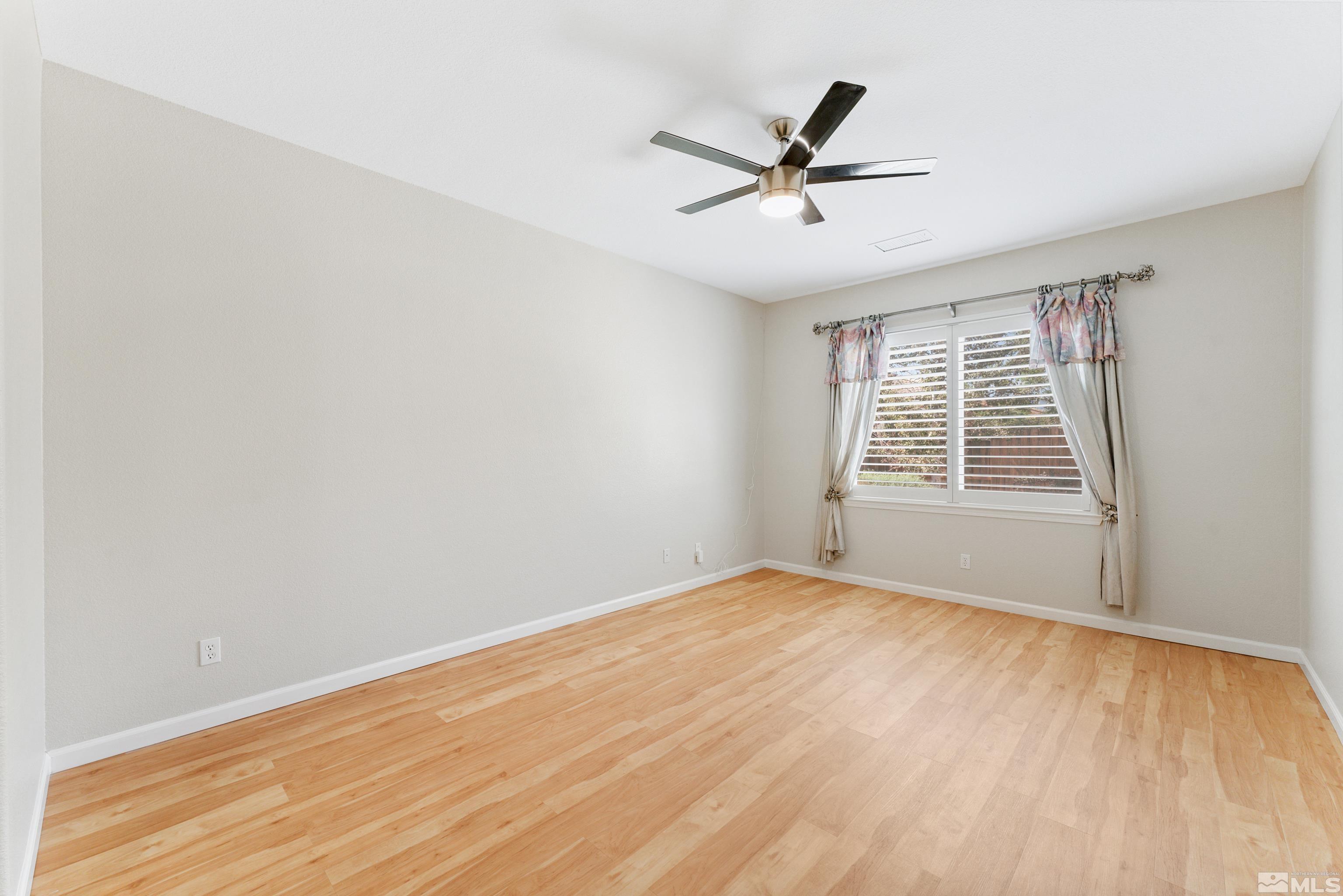 2195 Horse Prairie Road Reno, NV 89521 - Photo 19 of 39 a view of an empty room with wooden floor and a window