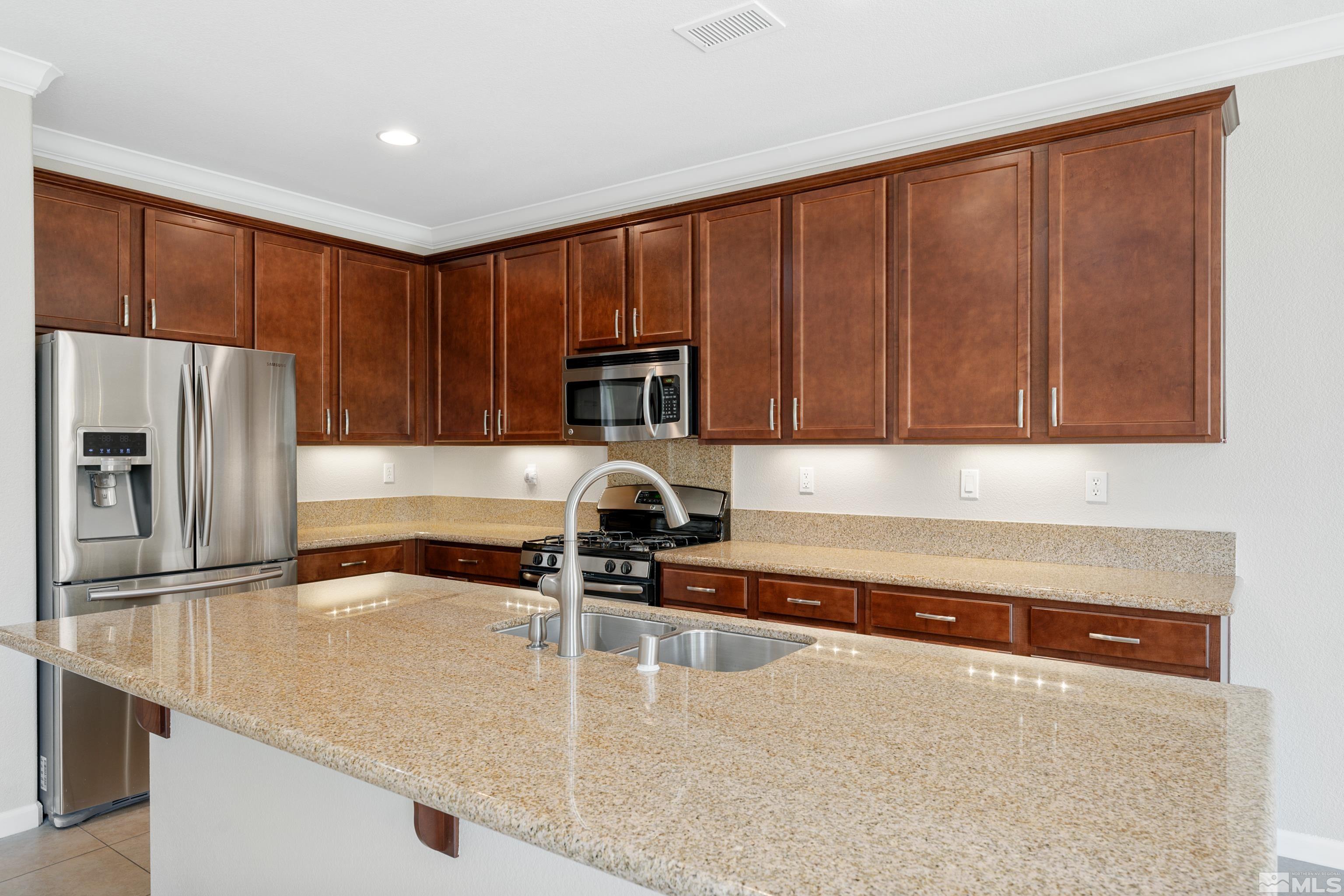 2195 Horse Prairie Road Reno, NV 89521 - Photo 6 of 39 a kitchen with stainless steel appliances granite countertop a refrigerator a stove and a sink with wooden cabinets