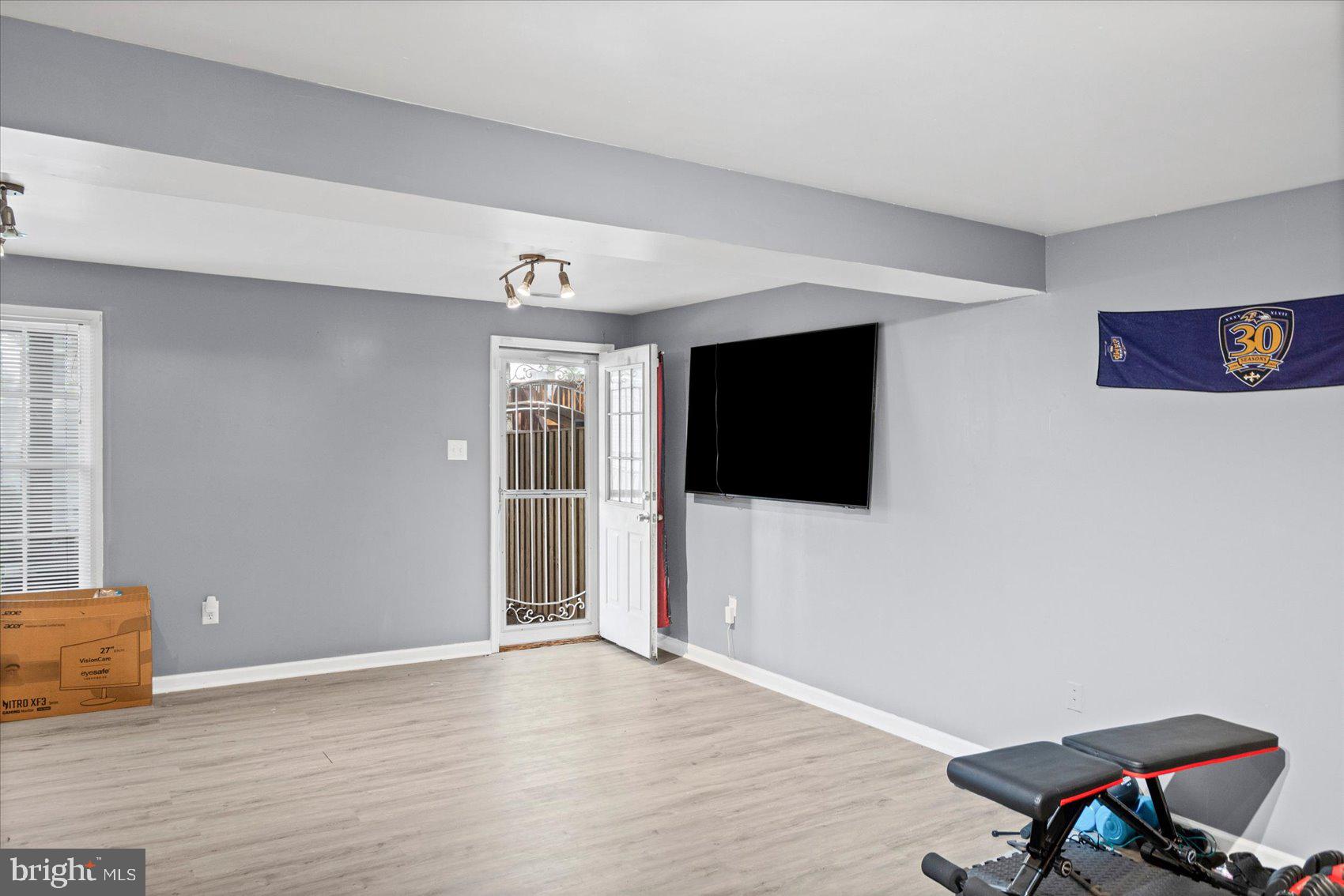 9965 Sherwood Farm Road Owings Mills, MD 21117 - Photo 26 of 35 a view of a livingroom with wooden floor and a flat screen tv