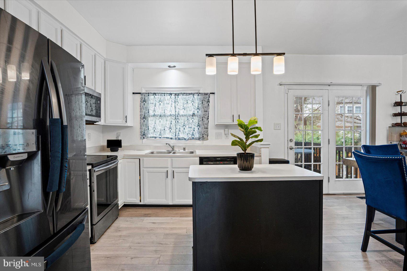 9965 Sherwood Farm Road Owings Mills, MD 21117 - Photo 7 of 35 a kitchen with a sink stainless steel appliances and white cabinets