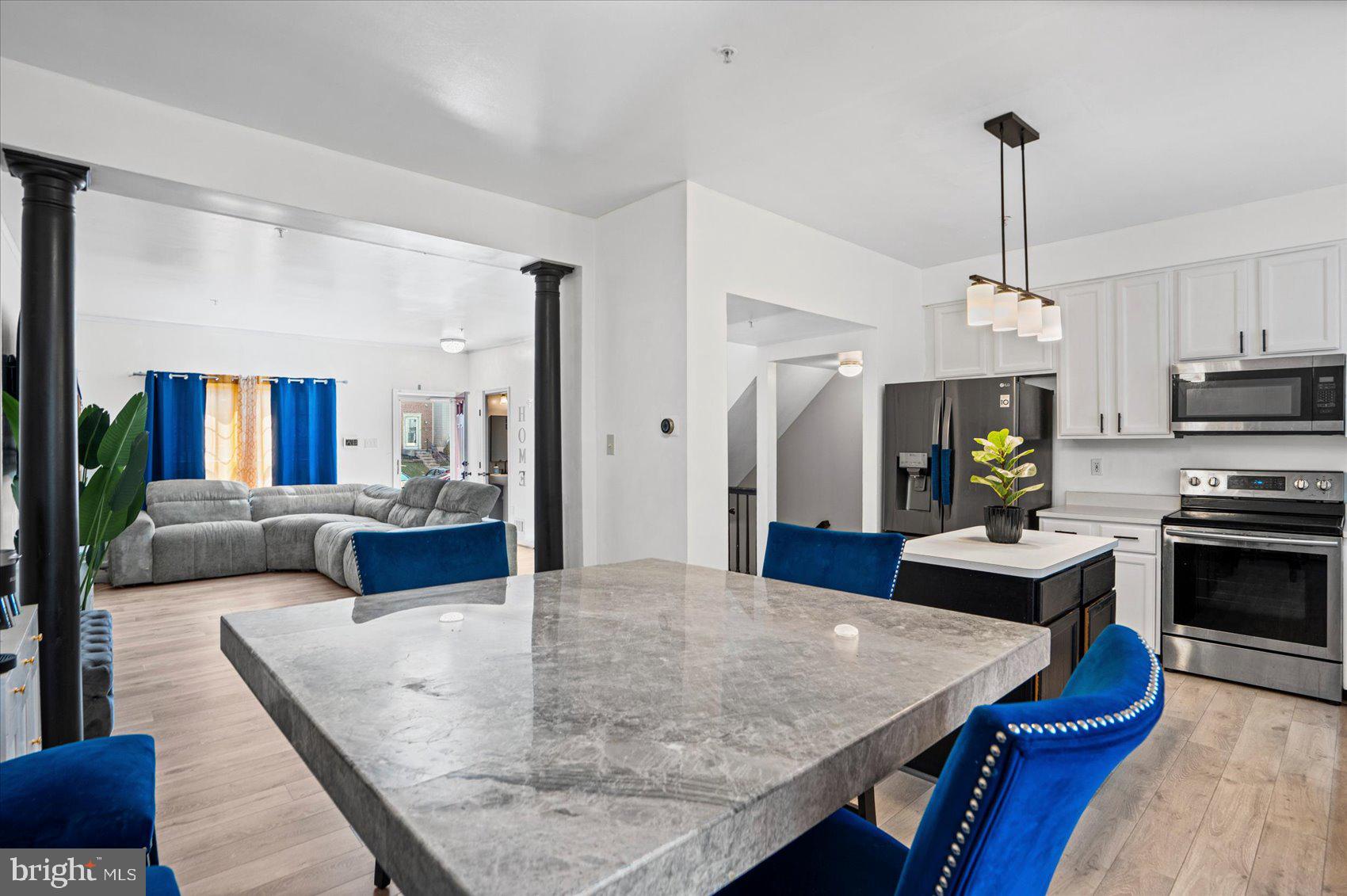 9965 Sherwood Farm Road Owings Mills, MD 21117 - Photo 9 of 35 a kitchen with kitchen island a stove a counter top space and living room view