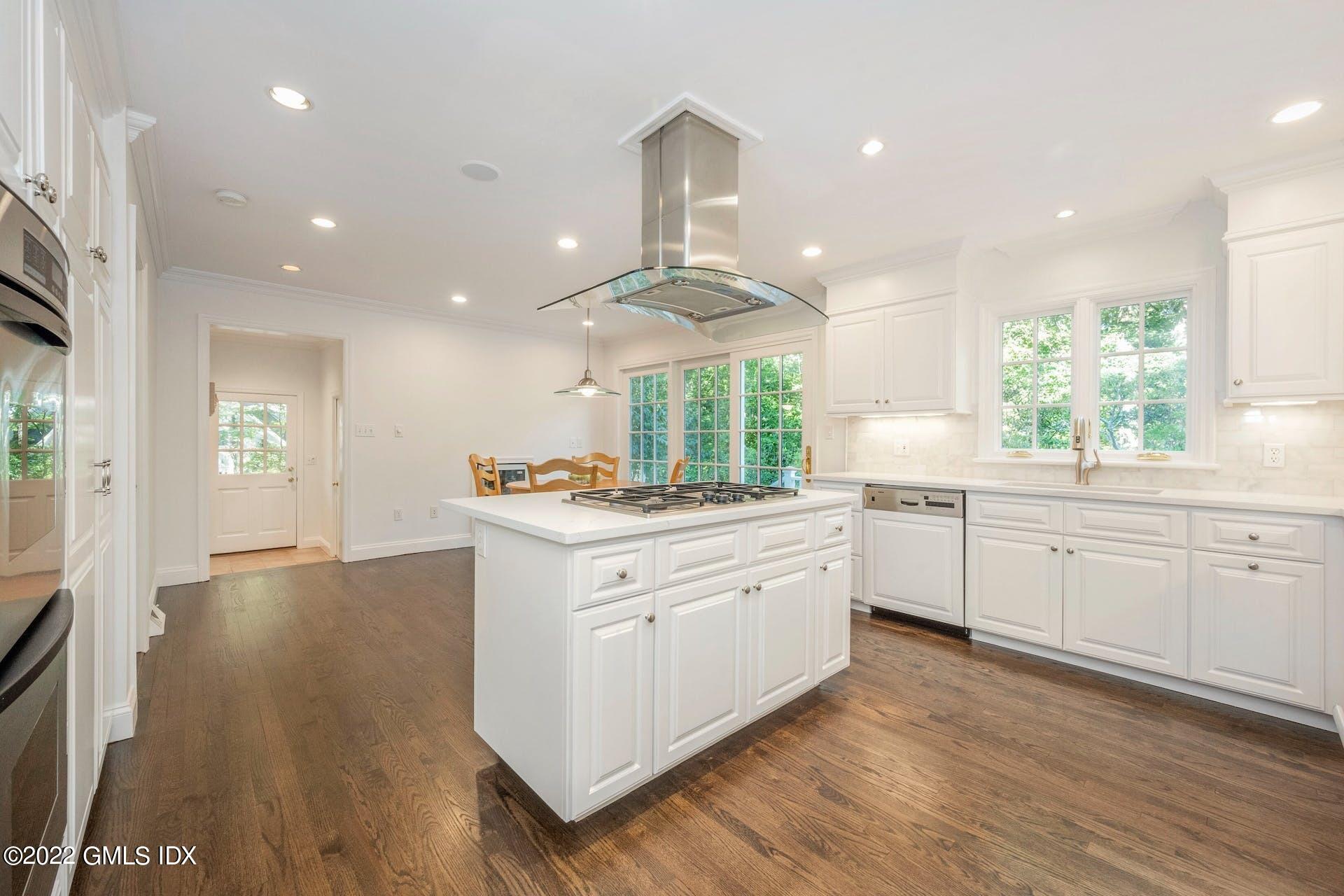 12 Frontier Road Cos Cob, CT 06807 - Photo 6 of 36 a large kitchen with stainless steel appliances a large counter top a sink and a chandelier