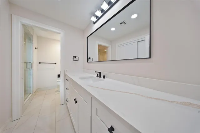 a bathroom with double vanity and mirrors