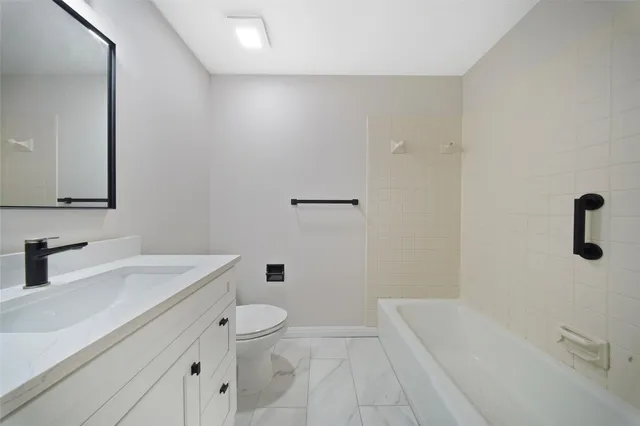 a spacious bathroom with a toilet sink and mirror