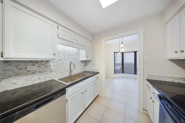a kitchen with granite countertop a sink and cabinets