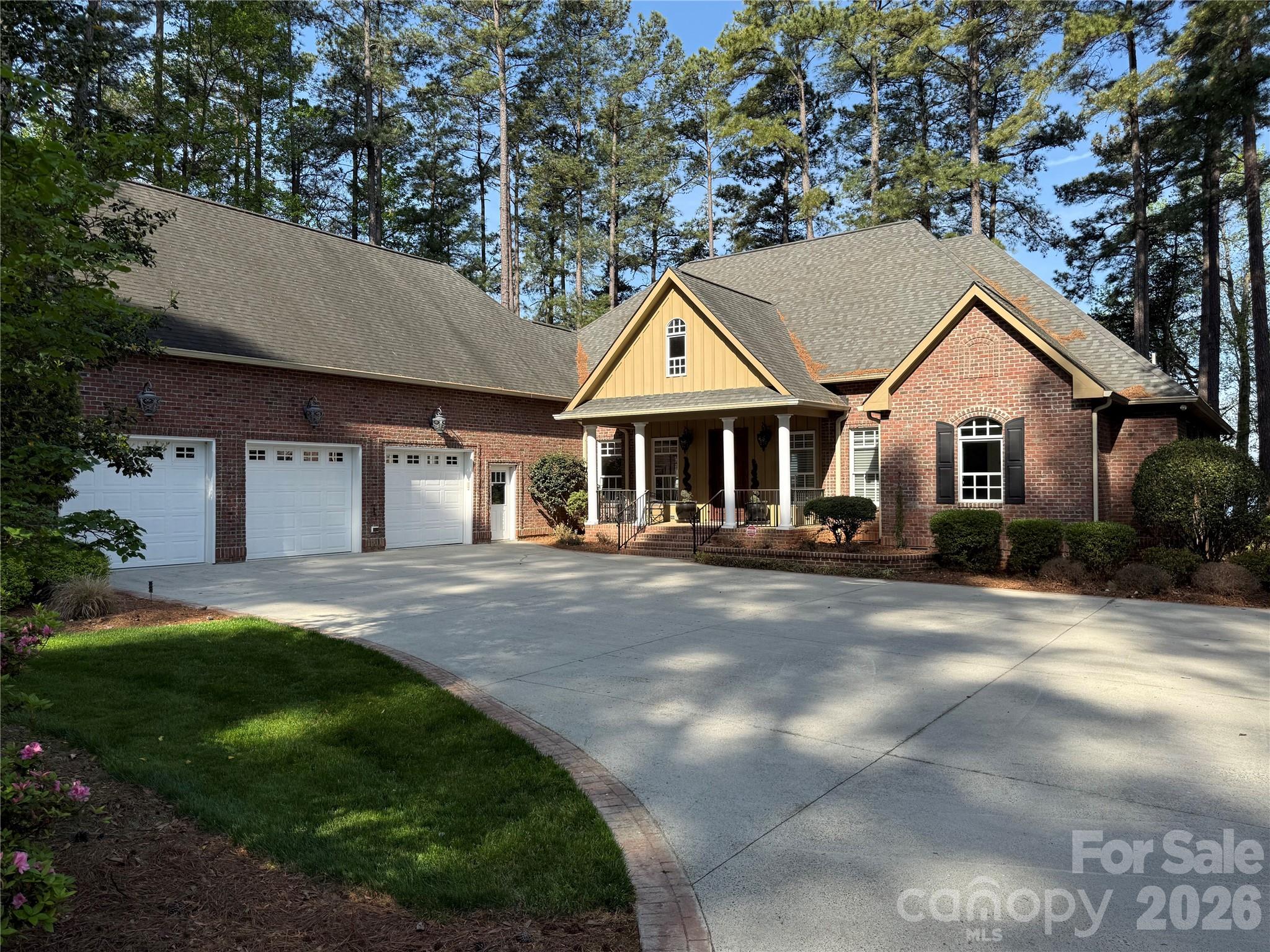 a front view of a house with a garden and trees