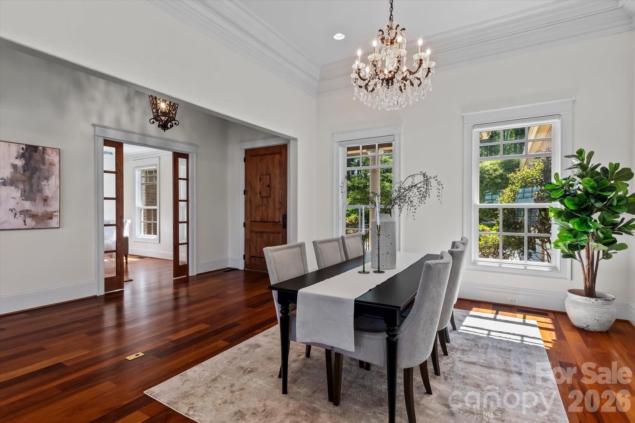 17821 Carlow Road Cornelius, NC 28031 - Photo 5 of 45 a dining room with wooden floor a chandelier a glass table and windows