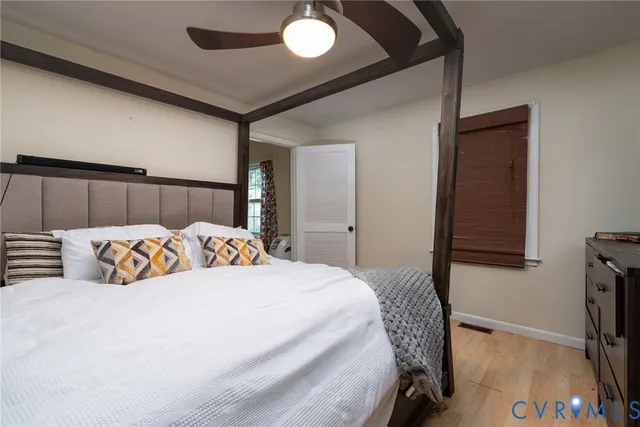 a bedroom with a bed and a flat tv screen on dresser