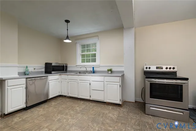 a kitchen with granite countertop cabinets stainless steel appliances and a sink