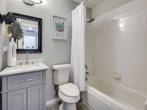 a bathroom with a granite countertop toilet a sink and a bathtub