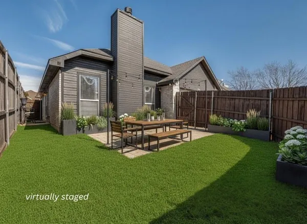 a view of a chair and table in backyard of the house