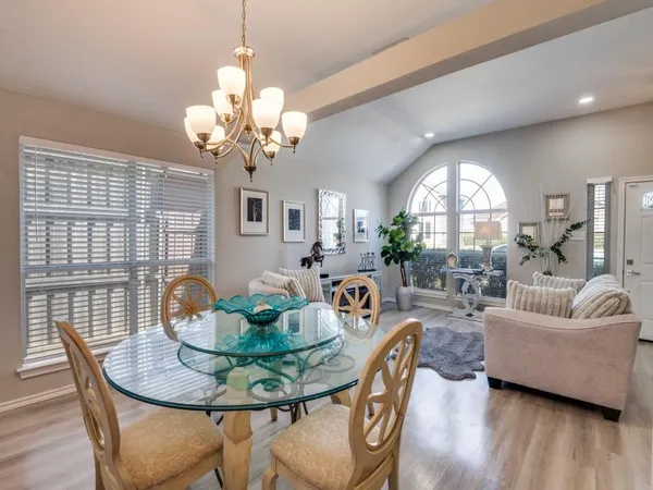 a view of a dining room with furniture a chandelier and wooden floor