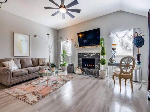 a living room with furniture a flat screen tv and a fireplace