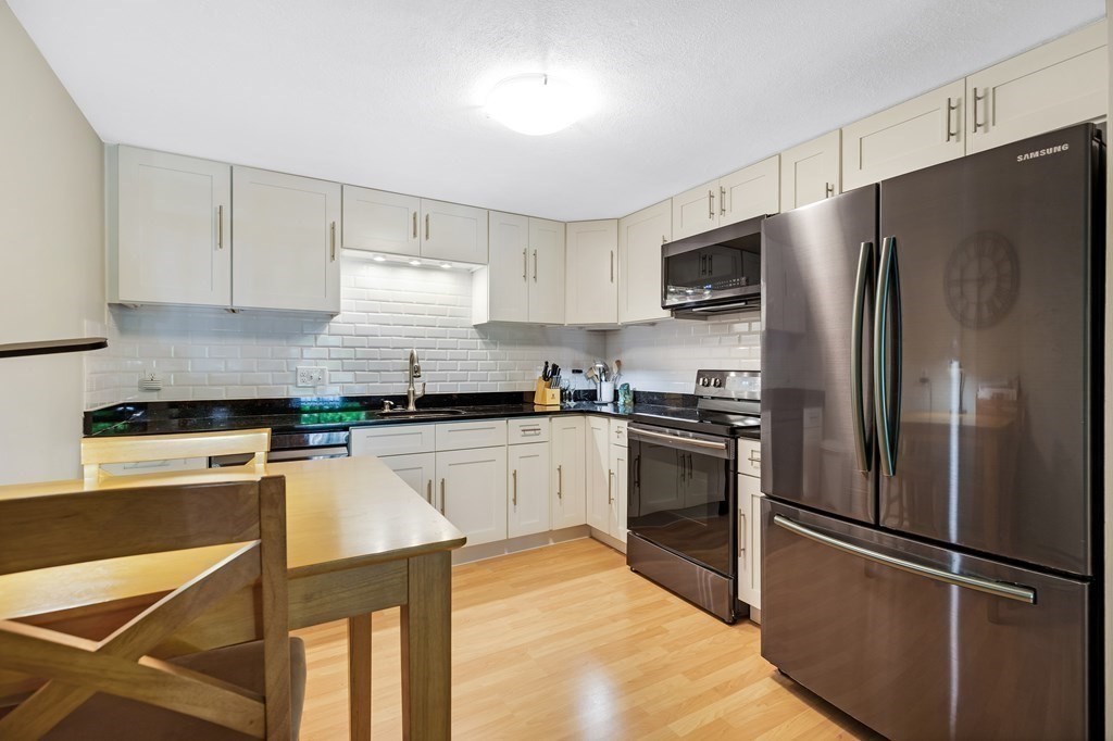 14 Walker Road, Unit 6 North Andover, MA 01845 - Photo 7 of 21 a kitchen with stainless steel appliances granite countertop a refrigerator stove a sink and dishwasher a oven with white cabinets