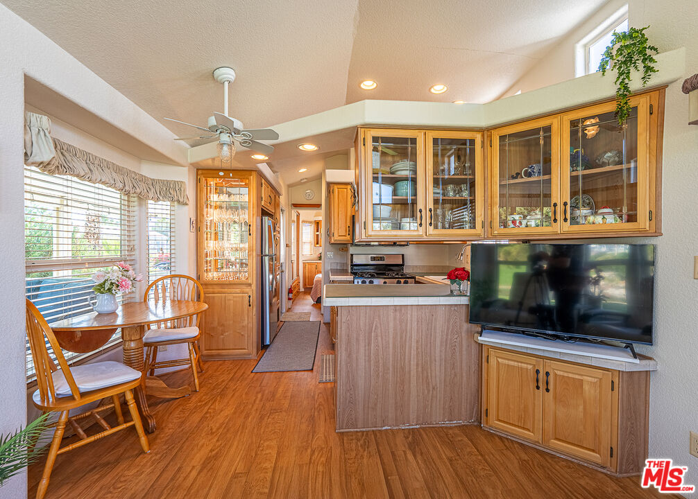 70200 Dillon Road, Unit 581 Desert Hot Springs, CA 92241 - Photo 10 of 23 a kitchen with stainless steel appliances granite countertop wooden floors and white cabinets