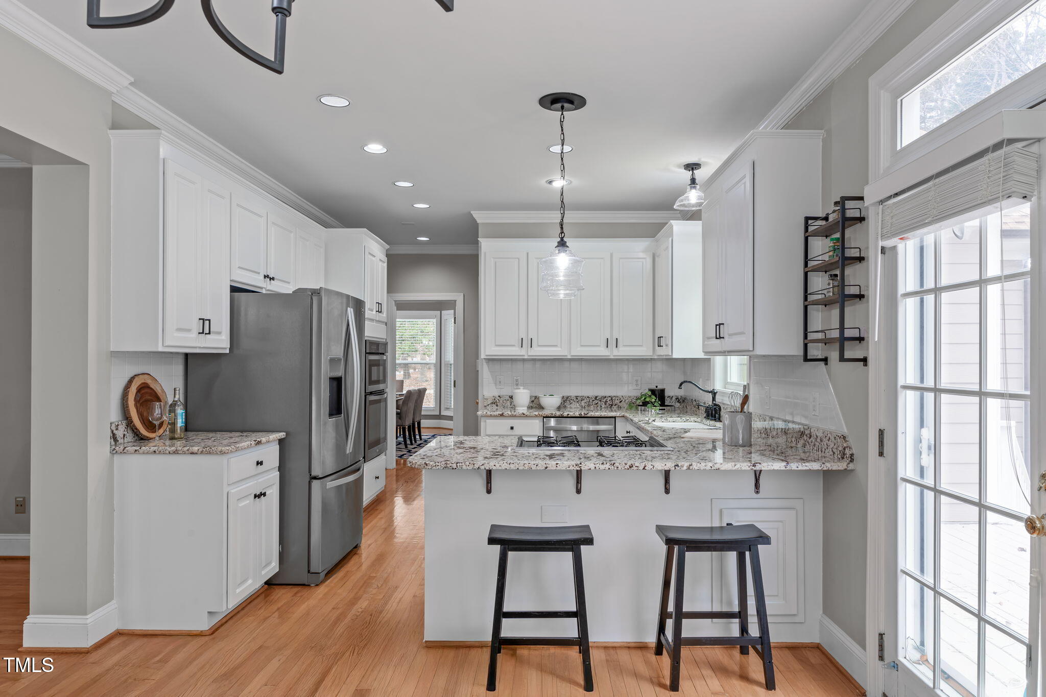 6016 Heatherstone Drive Raleigh, NC 27606 - Photo 11 of 40 a kitchen with stainless steel appliances granite countertop a refrigerator a sink dishwasher a stove and white countertops with wooden floor