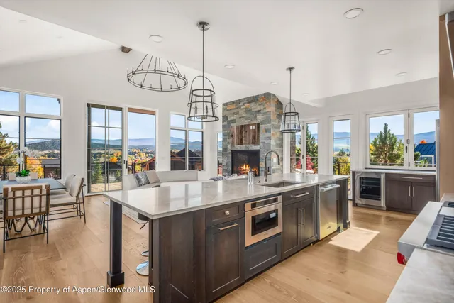 a large kitchen with stainless steel appliances granite countertop a stove and a view of living room