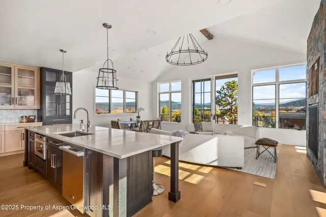 a large kitchen with a counter space a sink appliances and a large window