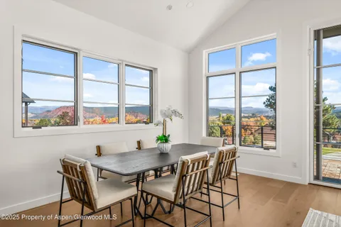 a view of a dining room with furniture large window and wooden floor