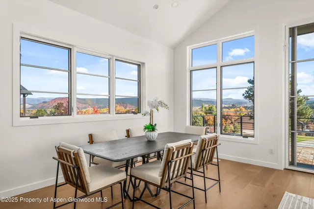 a view of a dining room with furniture large window and wooden floor