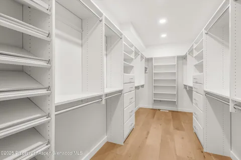 a view of walk in closet with empty racks