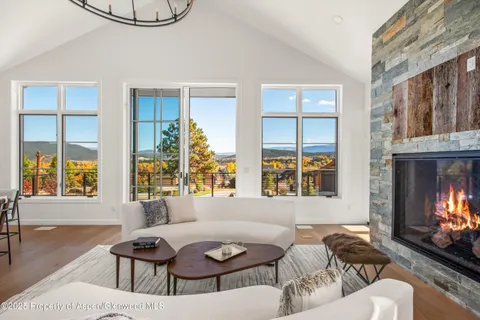 a living room with furniture a fireplace and windows