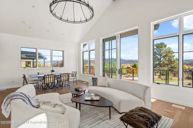 a living room with furniture a table and a large window