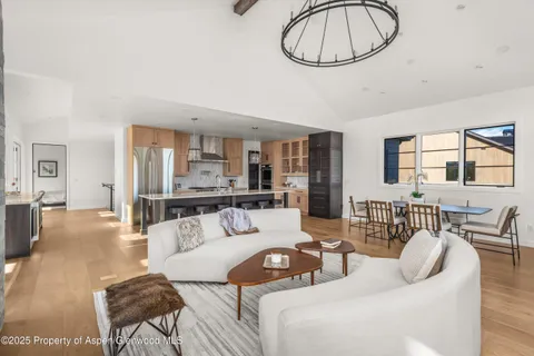 a living room with furniture a dining table and a chandelier