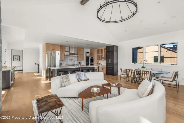a living room with furniture a dining table and a chandelier
