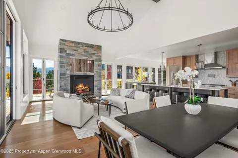 a living room with fireplace furniture and a dining table