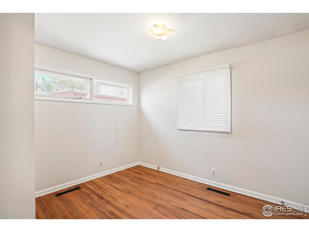 3120 Jefferson Street Boulder, CO 80304 - Photo 12 of 23 an empty room with wooden floor and windows