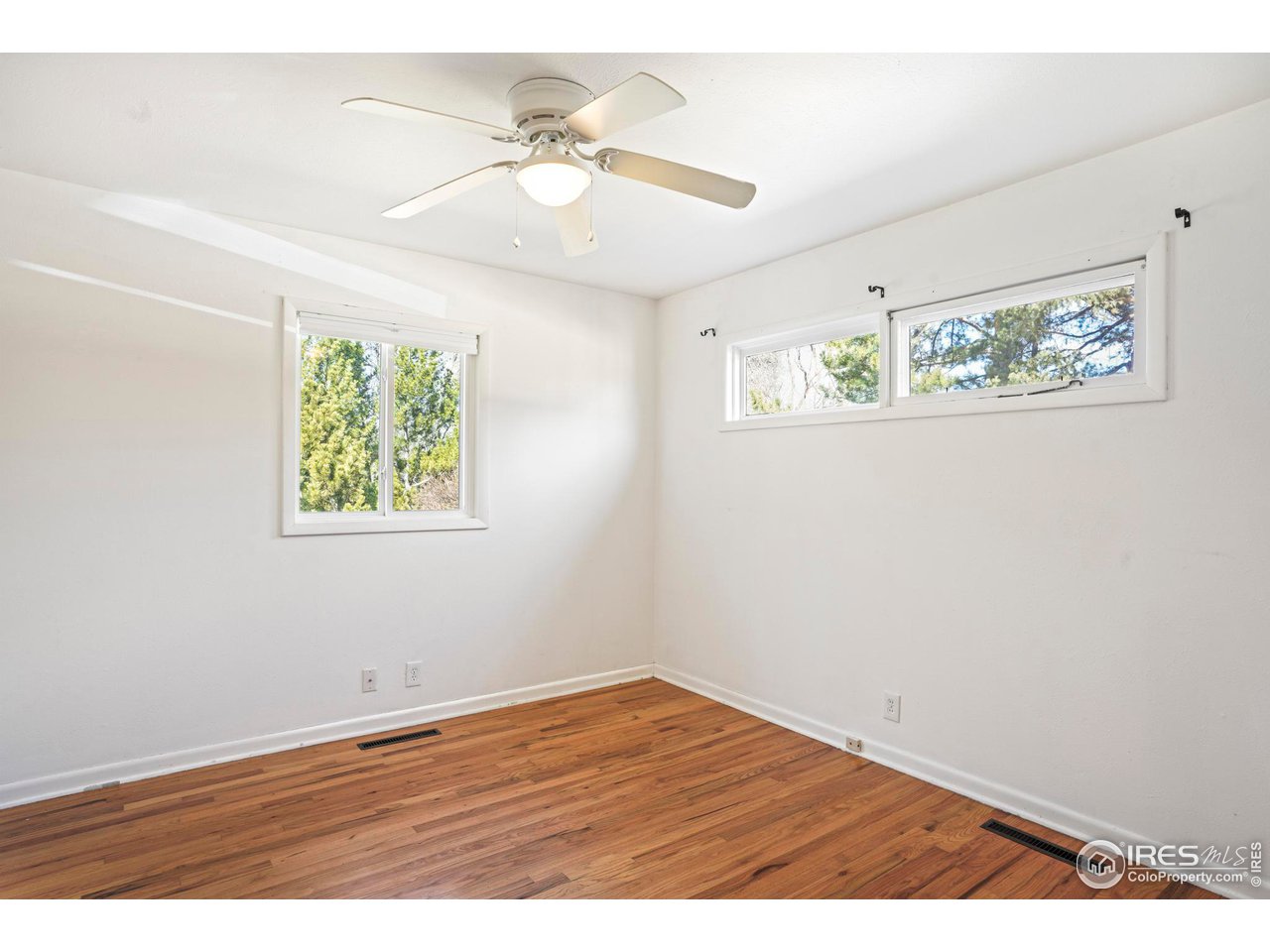 3120 Jefferson Street Boulder, CO 80304 - Photo 10 of 23 an empty room with wooden floor and window