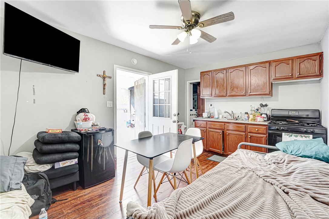 11068 Penrose Street Sun Valley, CA 91352 - Photo 18 of 27 a kitchen with stainless steel appliances granite countertop a stove top oven a sink a dining table and chairs with wooden floor