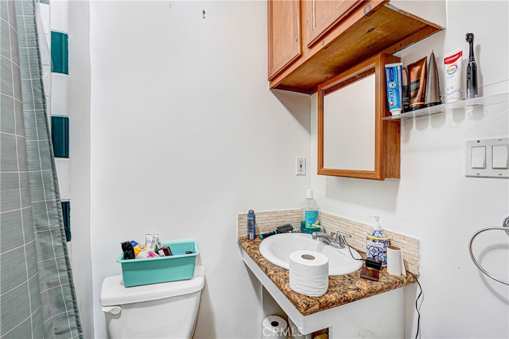 11068 Penrose Street Sun Valley, CA 91352 - Photo 19 of 27 a bathroom with a sink a toilet and a mirror