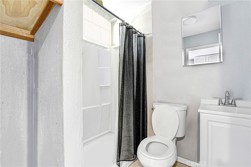 11068 Penrose Street Sun Valley, CA 91352 - Photo 22 of 27 a white toilet sitting next to a bathroom sink
