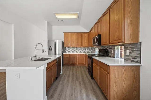 a kitchen with stainless steel appliances granite countertop a sink stove and cabinets