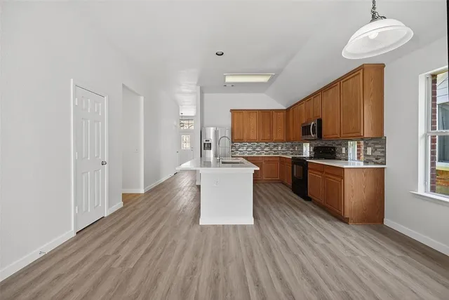a kitchen with wooden floors and refrigerator