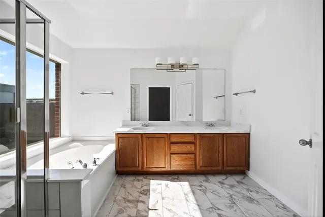 a bathroom with a tub sink and mirror