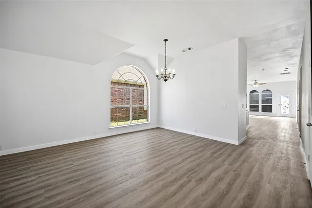 a view of a room with wooden floor staircase and a kitchen