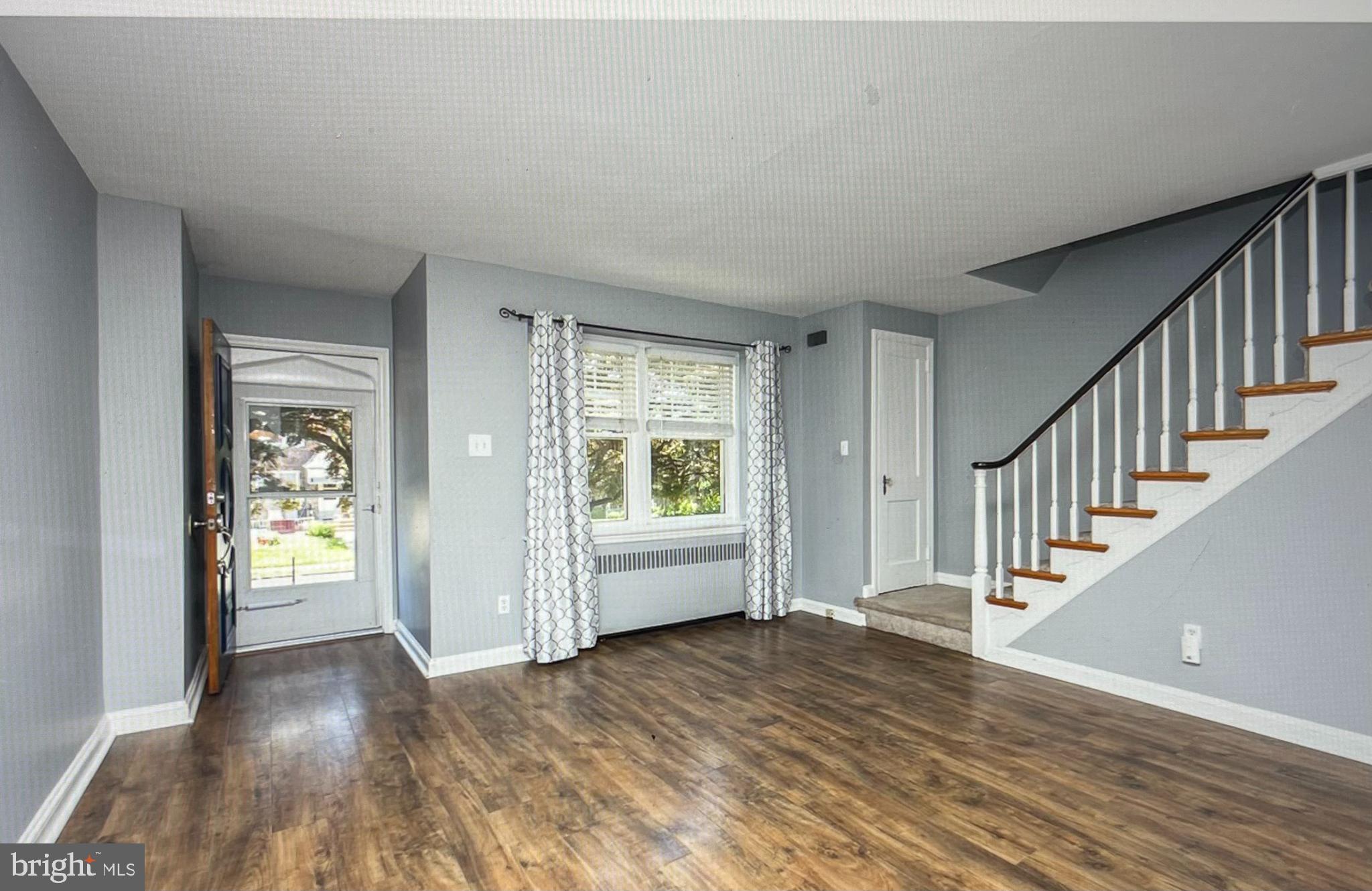 738 Eaton Road Drexel Hill, PA 19026 - Photo 3 of 16 a view of an empty room with wooden floor and a window