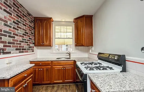 a kitchen with granite countertop a stove and a sink
